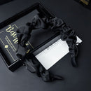 Flat lay with hair band folded to show satin sheen and stitching detail